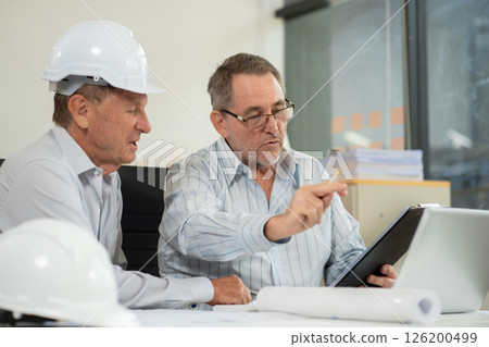 Engineering Team Collaborates on Blueprint Model in Corporate Office. 126200499