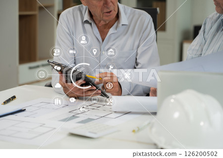 Engineering Team Collaborates on Blueprint Model in Corporate Office. 126200502