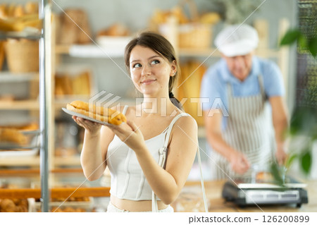 Portrait of a young girl with a bocadillo in her hands in the interior of private bakery Portrait of a young girl with a bocadillo in her hands in the interior of private bakery 126200899