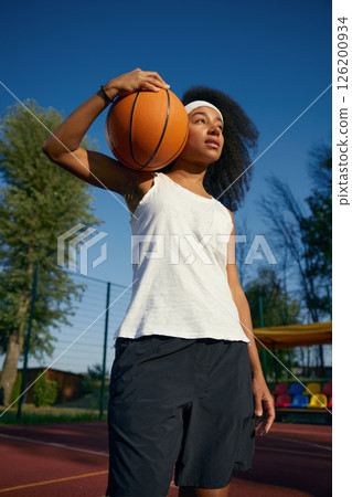 Teenage girl basketball player with ball over outdoor court background Teenage girl basketball player with ball over outdoor court background 126200934