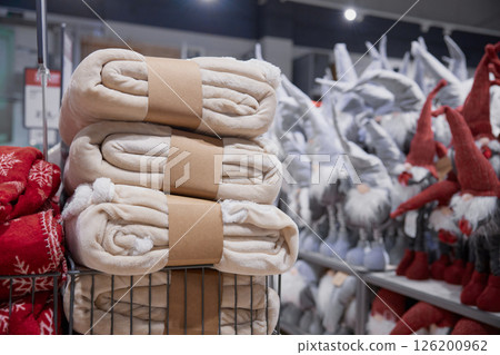 A neatly arranged stack of blankets stored in a basket within a store 126200962