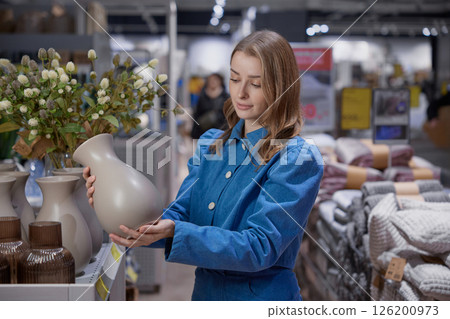 A woman browses a modern store for unique home decor to enhance her living space 126200973