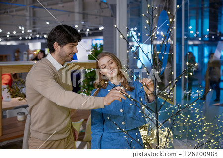 A joyful and festive family moment captured beautifully by the Christmas tree setting A joyful and festive family moment captured beautifully by the Christmas tree setting 126200983