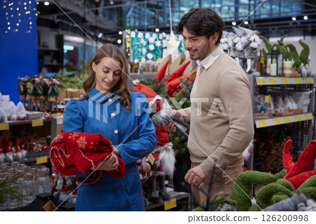 A couple enthusiastically shopping together for holiday decorations inside a store 126200998