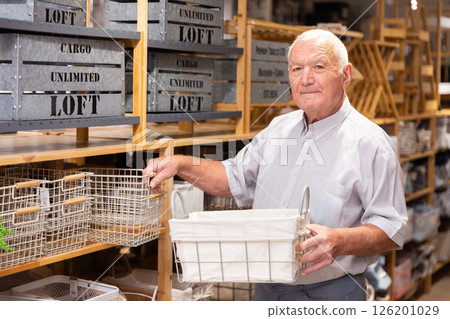 Elderly positive man choices metal basket at hardware store Elderly positive man choices metal basket at hardware store 126201029