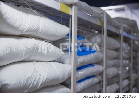 Shelving system features an organized arrangement of packed pillows within a storage facility 126201030