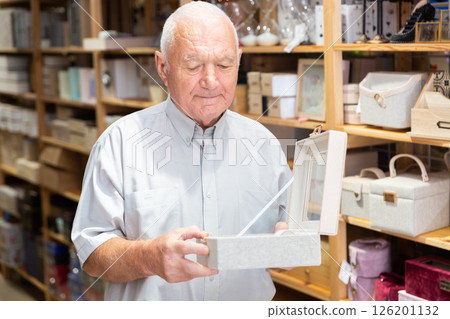 Elderly man looking for storage box for accessories 126201132