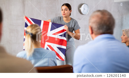 Young female teacher showing british flag to mature students 126201140