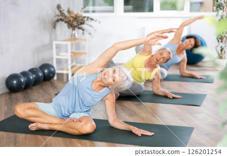 Group of elderly woman doing yoga on mat in studio 126201254