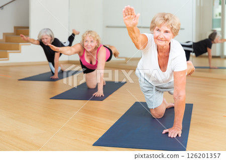 Mature active women perform a stretching exercise 126201357