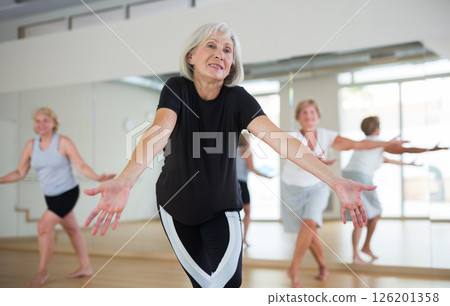 Positive aged woman practicing vigorous dance movements Positive aged woman practicing vigorous dance movements 126201358