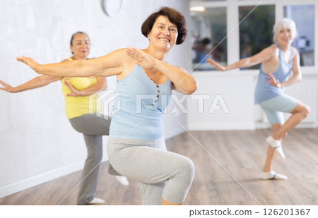 Happy mature woman practicing dance positions during workout session 126201367