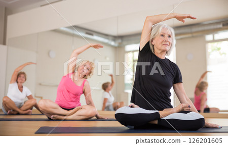 Elderly women practicing yoga trainin the lotus position 126201605
