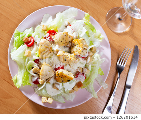Chicken breast with salad is served on plate with serving pieces Chicken breast with salad is served on plate with serving pieces 126201614