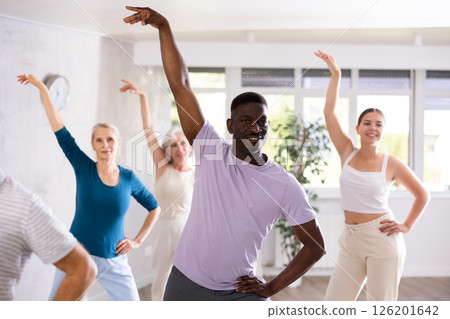 Men and women of different ages practicing Rock 'n' Roll dance in training hall 126201642