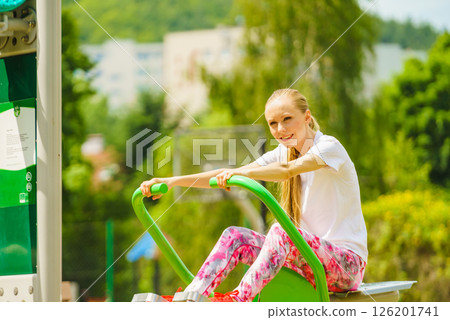 Girl doing legs exercise at outdoor gym area Girl doing legs exercise at outdoor gym area 126201741