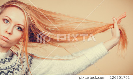 Teenage blonde girl brushing her hair with comb Teenage blonde girl brushing her hair with comb 126201761