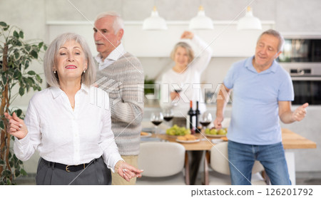 Elderly woman dancing in kitchen with friends Elderly woman dancing in kitchen with friends 126201792