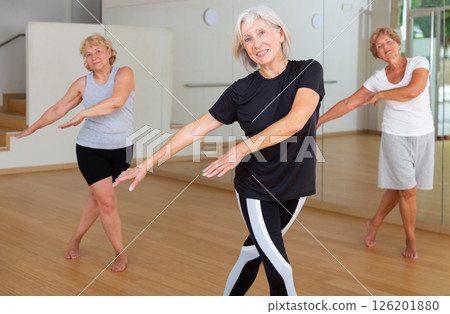 Aged women performing dance in fitness room 126201880