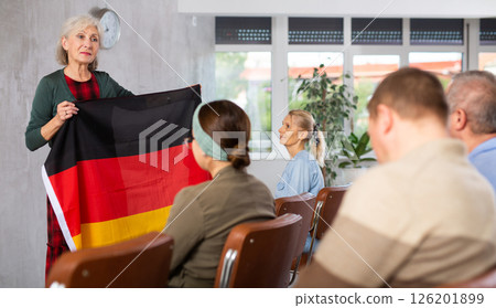 Mature female professor showing german flag to elderly students 126201899