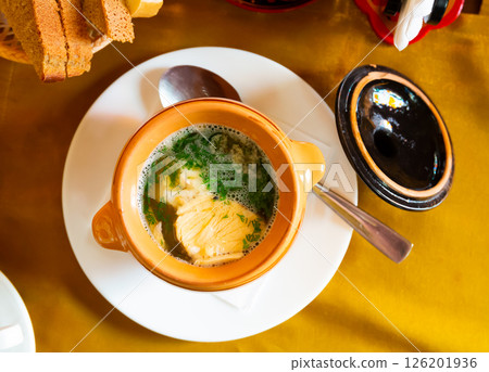 Fish soup with herbs in a pot. 126201936