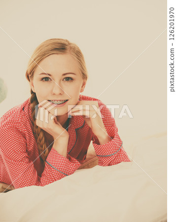 Smiling woman lying in bed 126201970