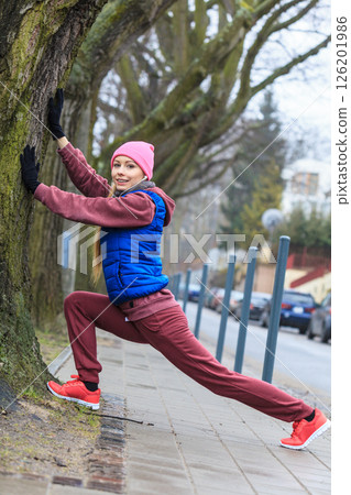 Woman wearing sportswear exercising outside during autumn 126201986