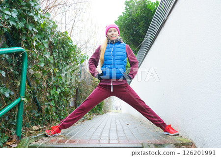 Woman wearing sportswear exercising outside during autumn Woman wearing sportswear exercising outside during autumn 126201991