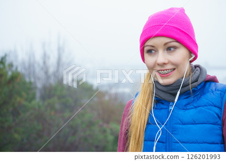 Woman wearing sportswear exercising outside during autumn 126201993