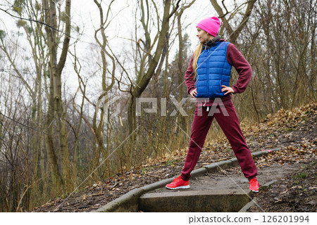 Woman wearing sportswear exercising outside during autumn Woman wearing sportswear exercising outside during autumn 126201994
