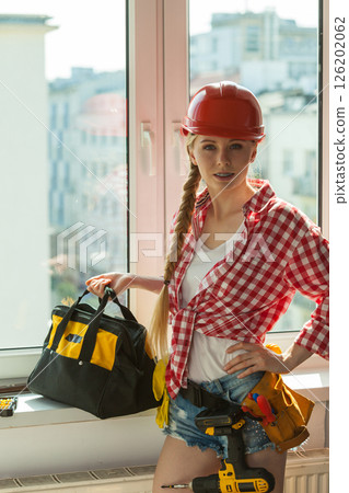 Woman with helmet next to the window 126202062