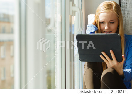 Sad teen woman using tablet Sad teen woman using tablet 126202353