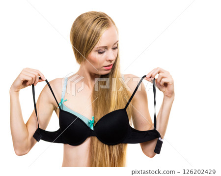 Woman trying on black pushup bra 126202429