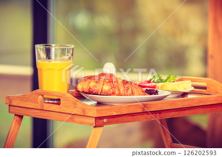 Breakfast on little table, orange juice croissant Breakfast on little table, orange juice croissant 126202593