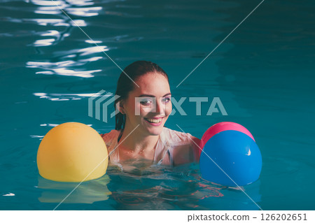 Happy woman in water having fun with balloons 126202651