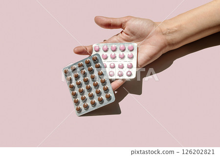 Woman Holding Two Packs of Dietary Supplements or Pills. Options for Nutrition and Wellness, with Daily Dosage Concept. 126202821