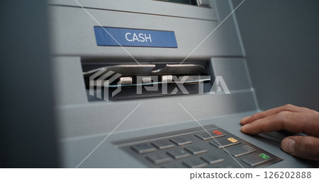 Close Up of Person Pressing Buttons on ATM Keypad, Entering PIN Code. ATM Dispensing Money Close Up of Person Pressing Buttons on ATM Keypad, Entering PIN Code. ATM Dispensing Money 126202888