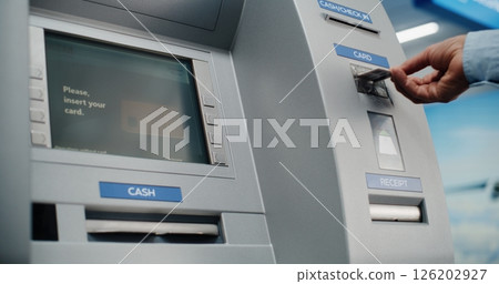 ATM Machine in Airport Terminal: Man Inserting Card, Pressing Buttons on ATM Keypad 126202927