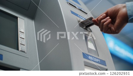 Cash Machine in Airport Terminal: Unrecognizable Person Inserting Plastic Credit Card Cash Machine in Airport Terminal: Unrecognizable Person Inserting Plastic Credit Card 126202931