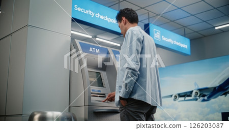 Cash Machine in Airport Terminal: Man Entering PIN Code for Cash Withdrawal Transaction, Taking Money 126203087