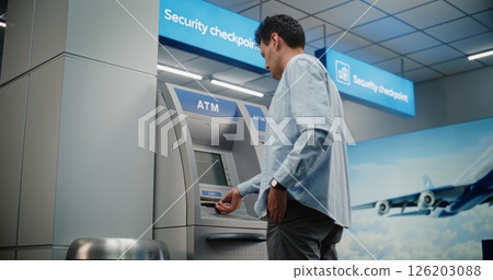 Cash Machine in Airport Terminal: Man Entering PIN Code for Cash Withdrawal Transaction, Taking Money 126203088