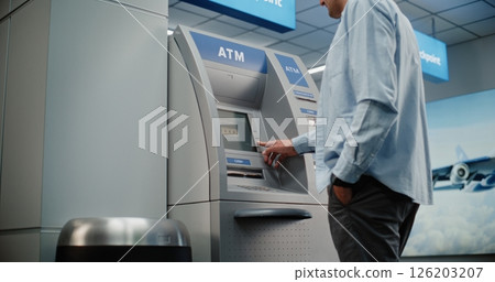 Airport Terminal: Man Pressing Buttons on ATM Keypad, Entering PIN Code, Withdrawing Cash, Taking Money 126203207