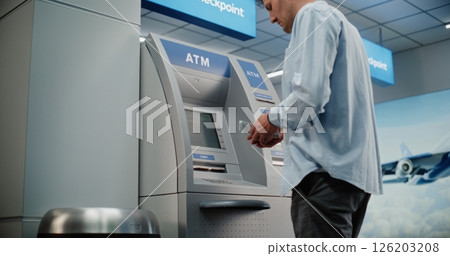 Airport Terminal: Man Pressing Buttons on ATM Keypad, Entering PIN Code, Withdrawing Cash, Taking Money 126203208