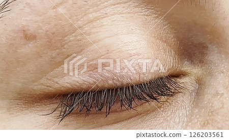 Focus on right green eye of attractive girl blinking and looking into camera. Portrait of upset female face. Sorrowful facial expression of young woman. Unhappy sight of beautiful lady. Close up 126203561