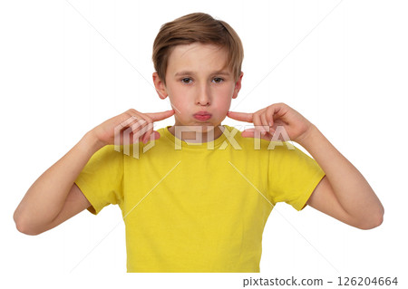 The teenage boy puffed out his cheeks and pointed at them with his finger. He is wearing a yellow T-shirt on a white background. 126204664