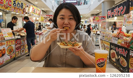 A woman eating junk food 126205238