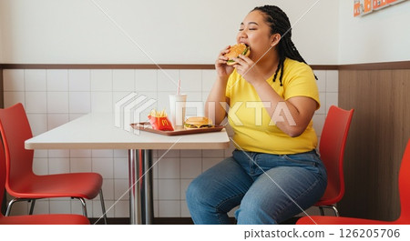 A woman eating junk food 126205706