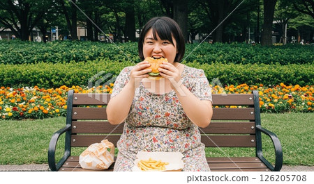 A woman eating junk food 126205708