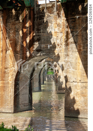 An arched bridge supporting railway tracks over a river An arched bridge supporting railway tracks over a river 126206984