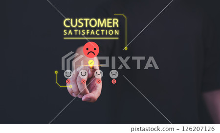 A hand selects a sad face on a customer satisfaction scale, indicating negative feedback. Bright text reads "Customer Satisfaction" above, reflecting an evaluation of customer experience. 126207126